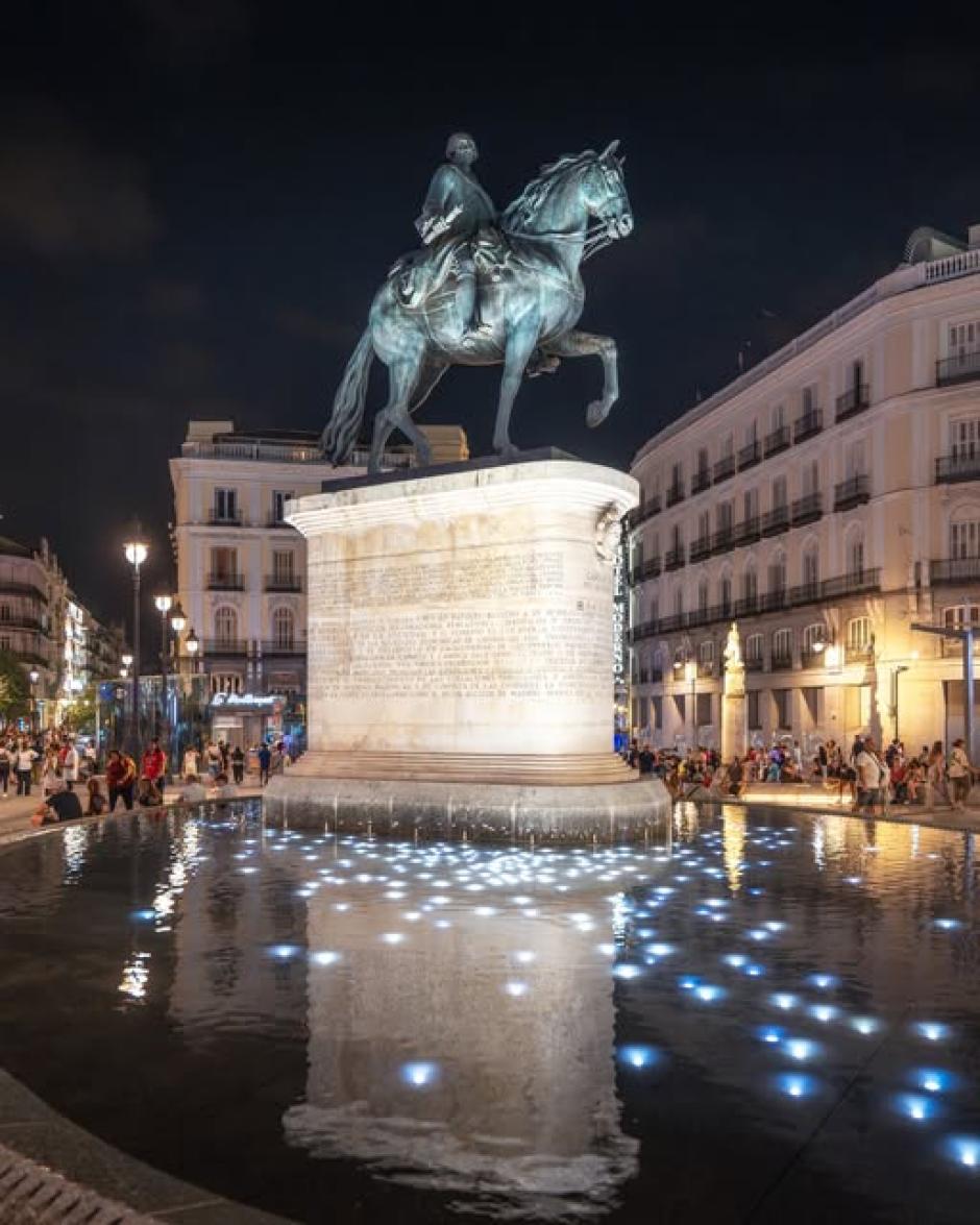 Carlos III sobre una fuente que se ilumina de noche