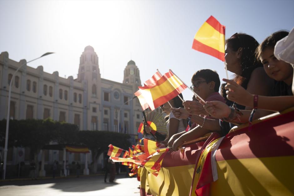 Numerosas personas con banderas de España antes de la visita de los Reyes Felipe VI y Doña Letizia a la Asamblea de Melilla