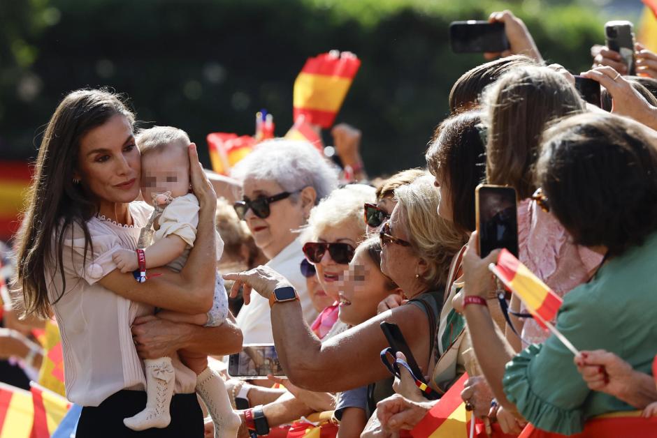 Doña Letizia coge en brazos a un bebé mientras saluda a los ciudadanos de Melilla