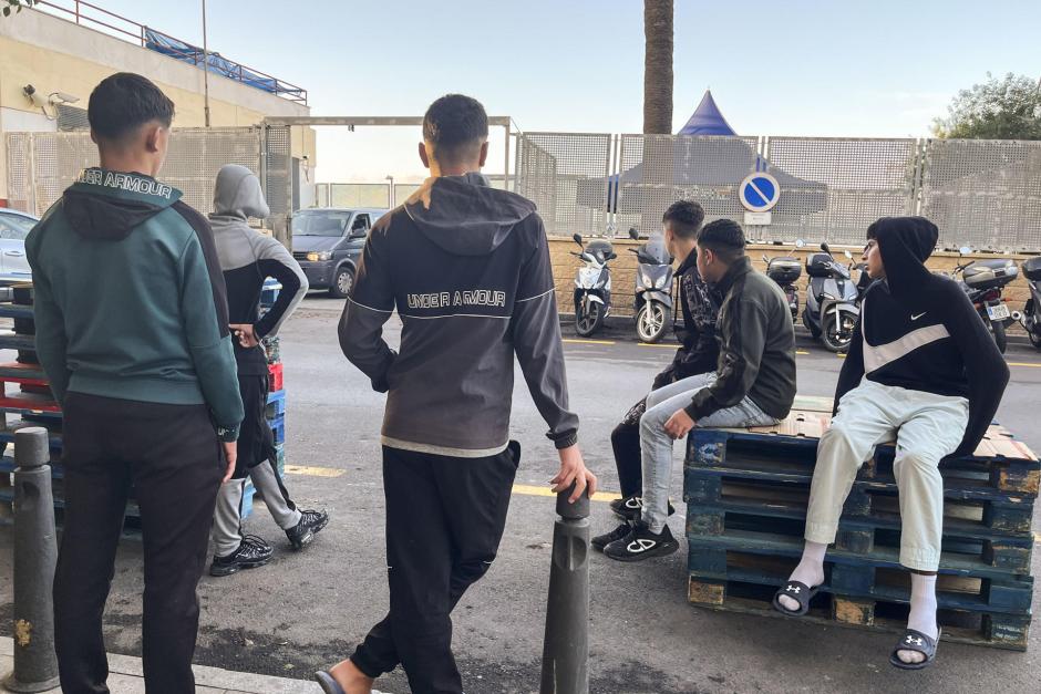 Menores inmigrantes esperan  frente a la Jefatura Superior de la Policía Nacional de Ceuta