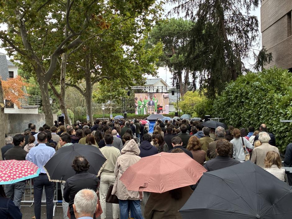 Cientos de fieles siguen la misa en la calle adyacente a la parroquia