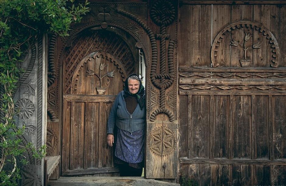 Mujer local en una puerta de madera labrada de la región de Maramures