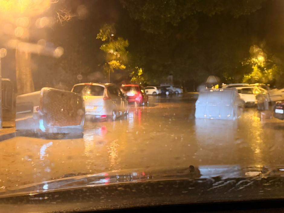 Contenedores flotando en una calle del barrio alicantino de Santa Faz