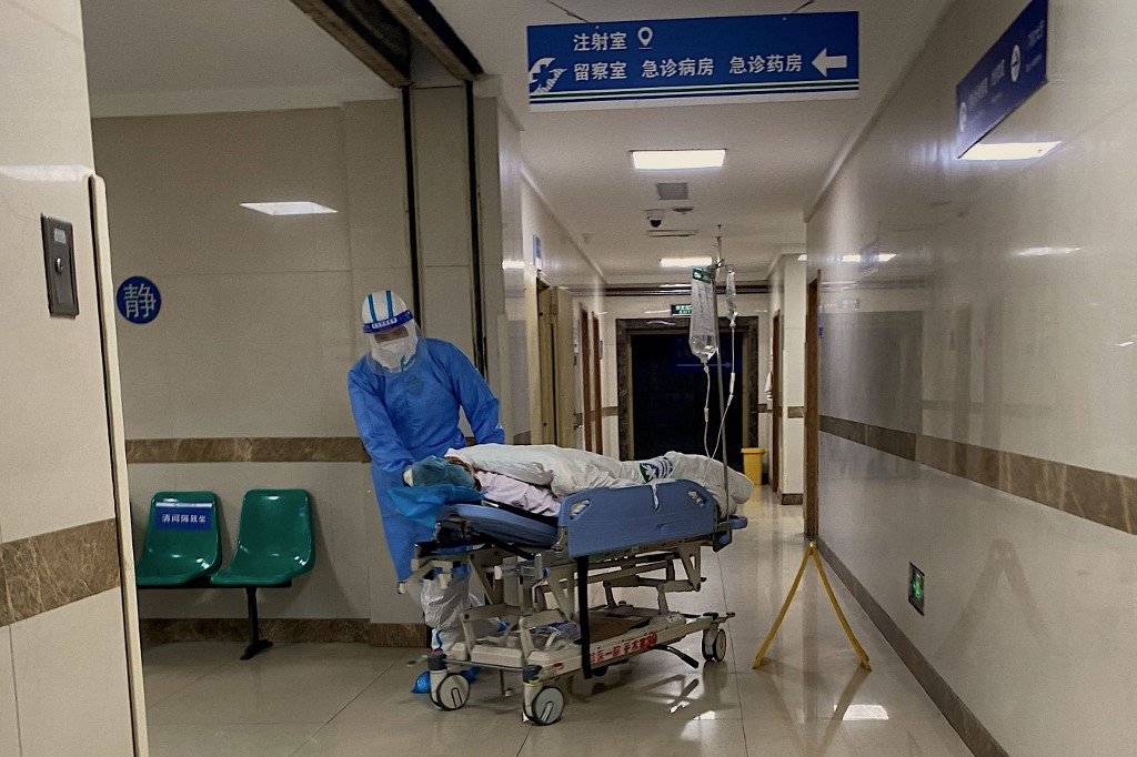 Un enfermero transporta a un paciente de covid en el hospital de Chongqing, al suroeste de China.